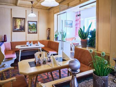 Coin confortable avec banquettes et murs en bois, décoré de plantes et de tableaux.