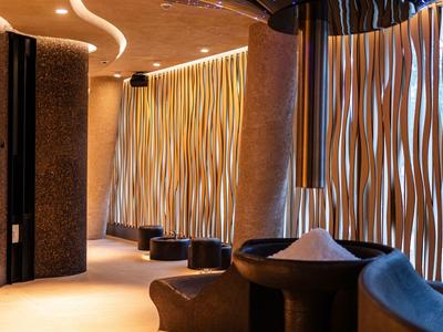 Elegante hotel lounge met gebogen wandelementen en gedimde verlichting.