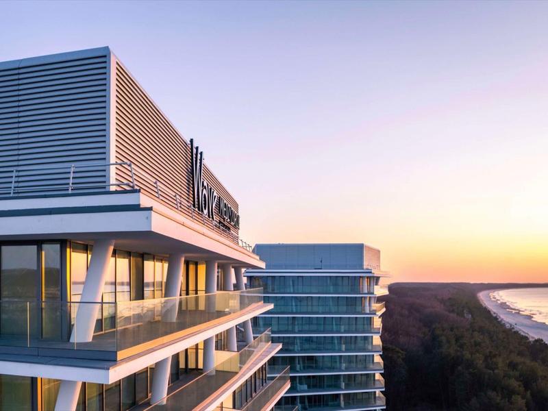 Moderne hotelstructuur bij zonsondergang met uitzicht op strand en zee