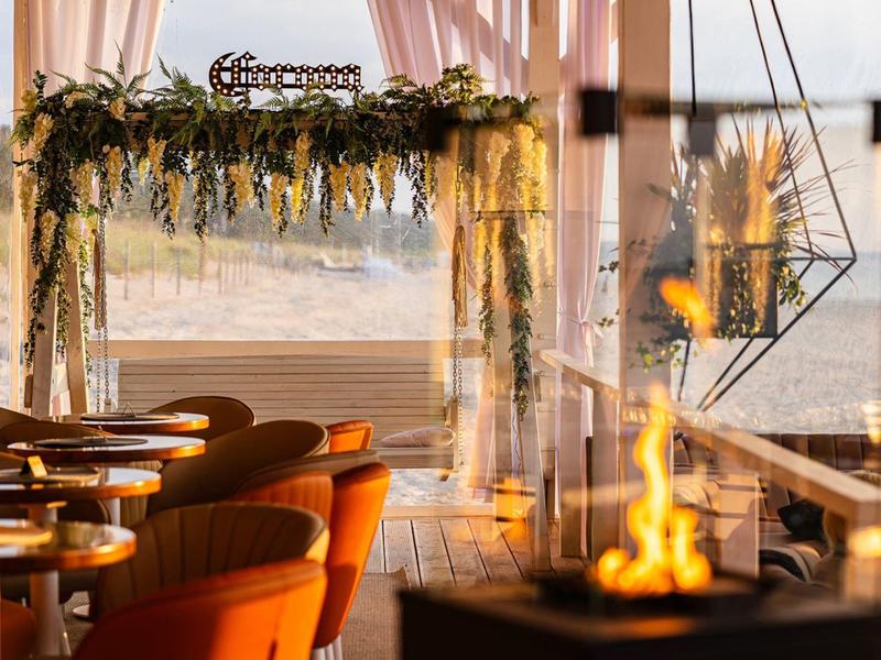 Elegante zithoek met uitzicht op zee, versierd met bloemen en nabij een open haard