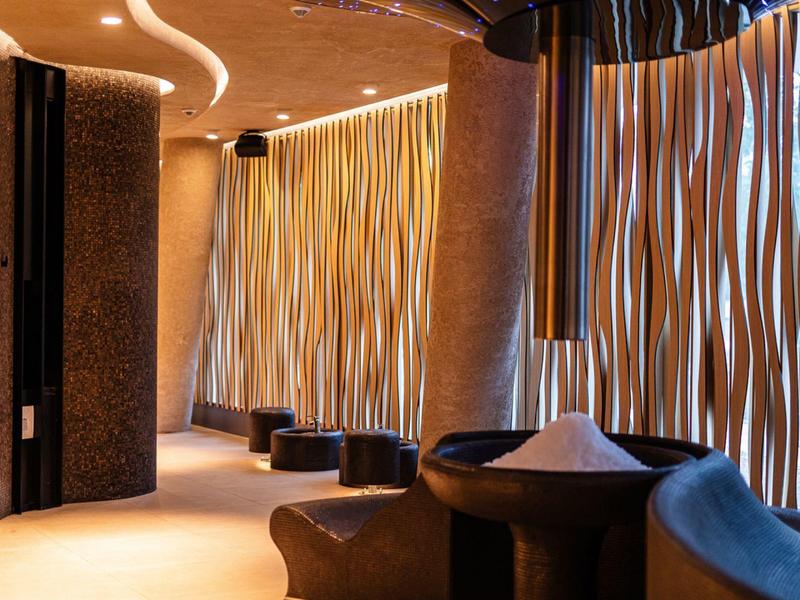 Elegante hotel lounge met gebogen wandelementen en gedimde verlichting.