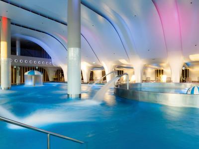 Moderner Innenpool mit sanfter Beleuchtung und Wasserfontänen in einem Hotel