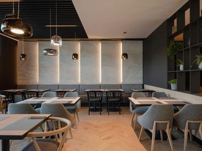 Moderner Essbereich mit heller Holzmöblierung und indirekter Beleuchtung an der Wand.