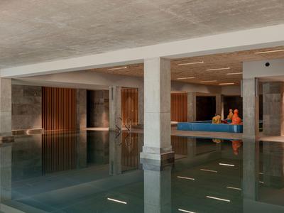 Modernes Hallenbad mit klaren Wasserflächen und Sitzbereich im Hintergrund.