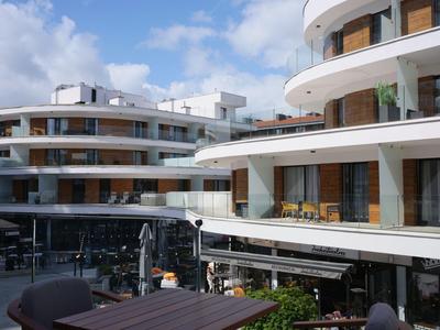 Moderne Hotelgebäude mit Balkonen und Sitzbereichen unter blauem Himmel.