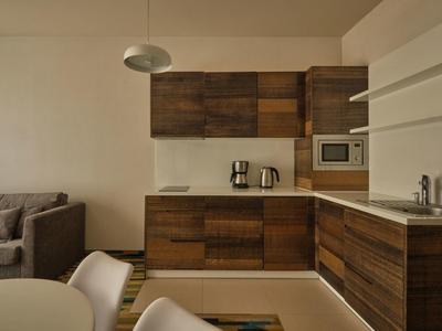 Cucina moderna con ante in legno in un appartamento accogliente con divano.