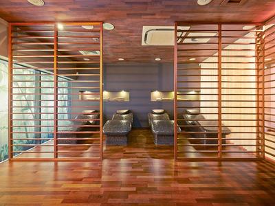 Moderner Wellnessbereich mit Liegestühlen, Holzlatten und warmem Licht.