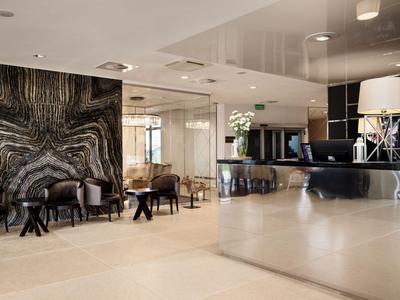 Moderne Hotellobby mit glänzendem Empfangstresen und stilvollen Sitzbereichen.