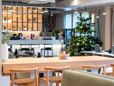 Modern eingerichteter Hotel-Loungebereich mit Holzmöbeln und Weihnachtsbaum.