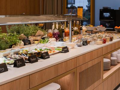 Buffet mit verschiedenen frischen Speisen, Salaten und Beilagen in einem modernen Hotelrestaurant.
