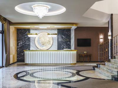 Hall d'hôtel luxueuse avec réception moderne, sol en marbre et éclairage élégant.