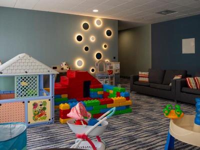 Speelruimte voor kinderen met kleurrijk speelgoed en comfortabele zitplaatsen in een hotelkamer.