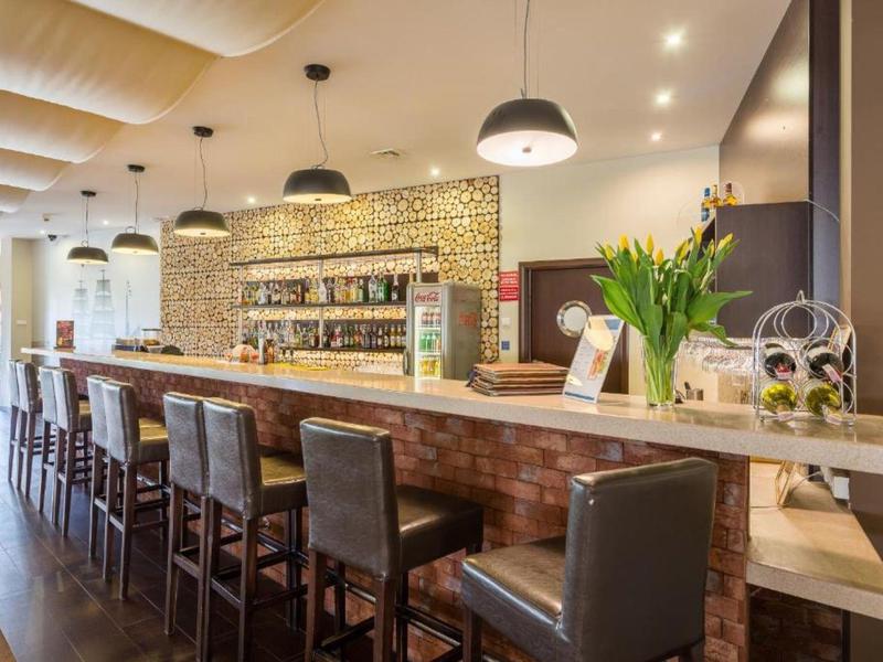 Moderner Hotelbarbereich mit hohen Ledersesseln und stilvoller Beleuchtung