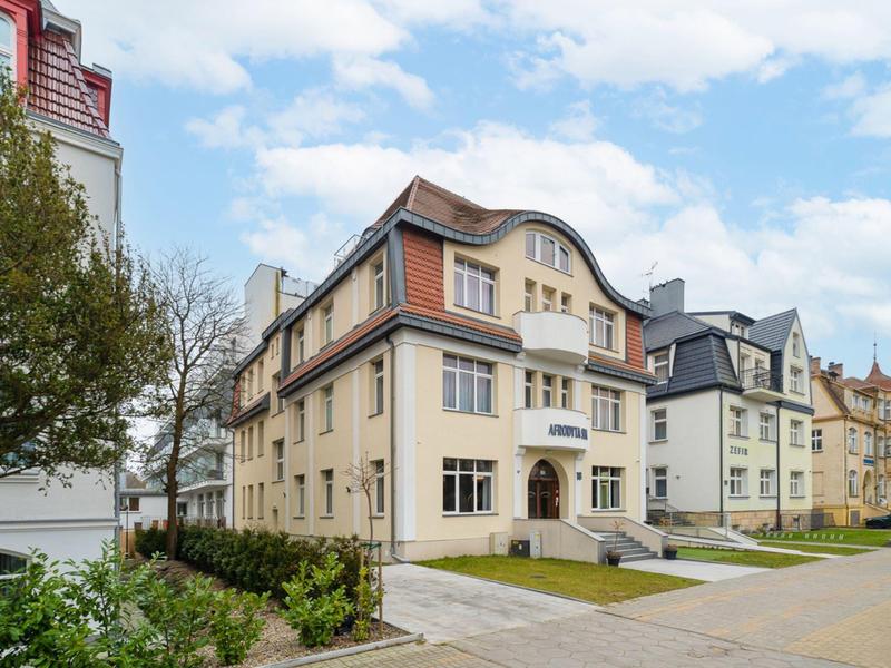 Großes historisches Haus mit Mansardendach in einer ruhigen Wohnstraße bei Tageslicht