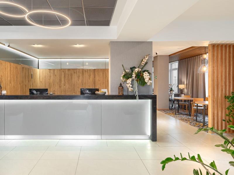 Moderner Hotel-Empfang mit hellen Materialien und stilvoller Beleuchtung.