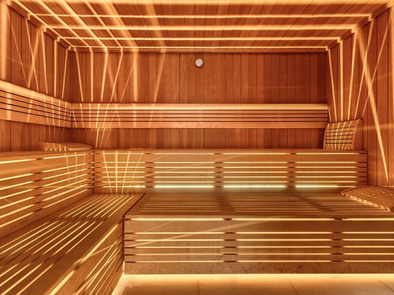 Moderne Sauna mit Holzverkleidung und indirekter Beleuchtung