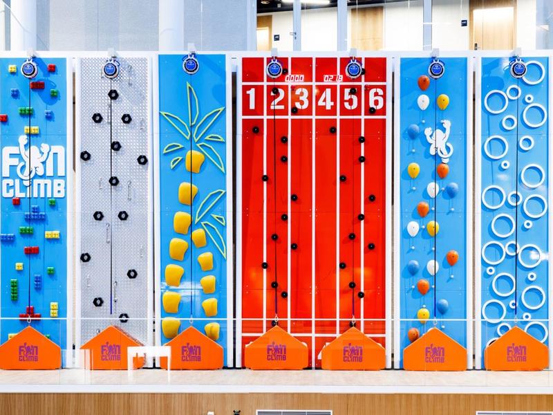Paredes de escalada coloridas en un centro deportivo interior con diversas presas y obstáculos.