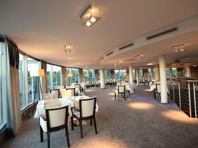 Moderní restaurace s velkými okny a pohodlnými židlemi v světlém prostředí