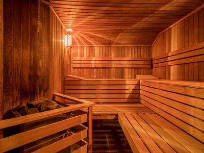 Interior de una sauna bien iluminada con paneles y bancos de madera.