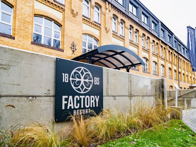 Außenansicht eines gelben Backsteingebäudes mit dem Schild Factory 1886 an der Wand.