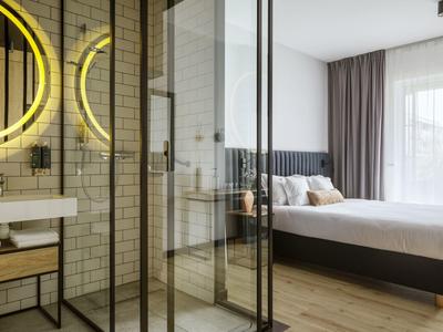 Nowoczesny pokój hotelowy z przeszkloną prysznicem, wygodnym łóżkiem podwójnym i dużym oknem z zasłonami