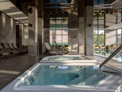 Nowoczesny jacuzzi wewnętrzny w luksusowej strefie spa z naturalnym światłem.