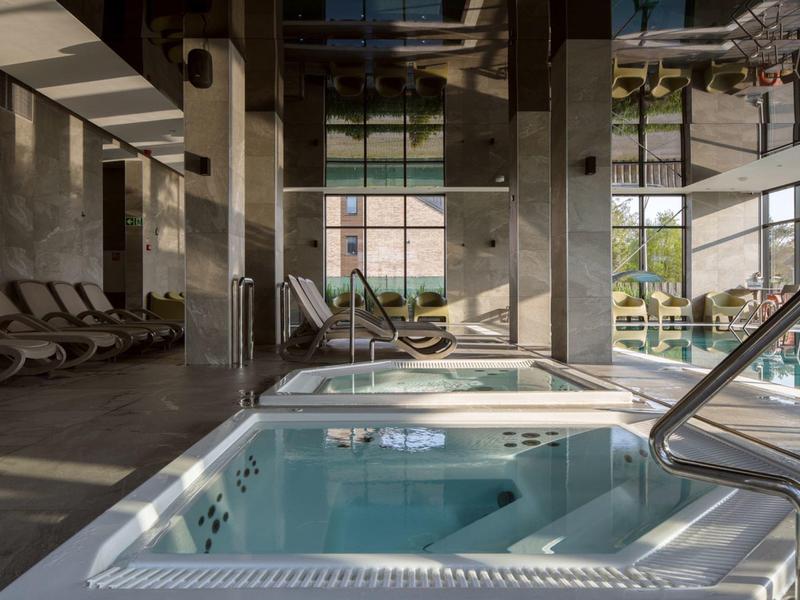 Nowoczesny jacuzzi wewnętrzny w luksusowej strefie spa z naturalnym światłem.