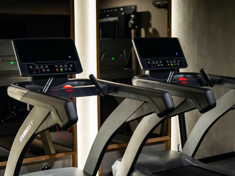 Dwie bieżnie z ekranami w strefie fitness hotelu.
