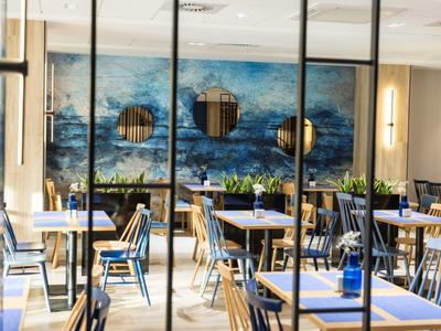 Restaurante moderno con sillas azules y mural de pared con tema marino