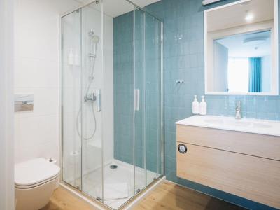 Modernes Badezimmer mit Dusche, WC und Waschbecken in hellem, freundlichem Design.
