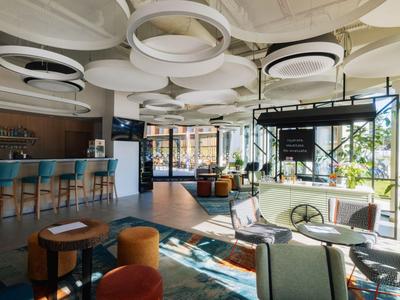 Modern eingerichtete Hotelbar mit kreativem Decken-Design und Sitzgelegenheiten in warmen Farben.