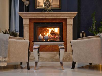 Gemütliche Sitzecke mit Kamin, Tisch und Dekoration in warmem Ambiente.