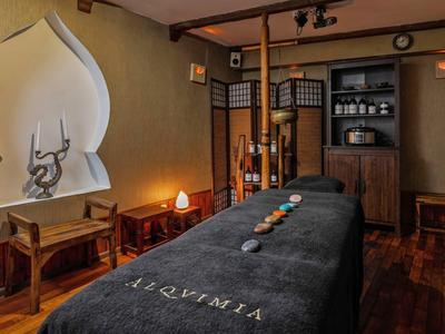 Gemütlicher Massageraum mit dunklem Massagetisch und warmem Licht