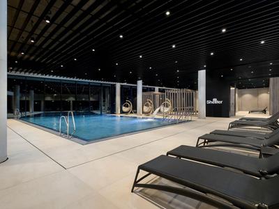 Moderna zona de piscina cubierta con tumbonas e iluminación relajante en un hotel.