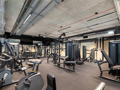 Gimnasio moderno con varias máquinas de ejercicio y pesas en un hotel.