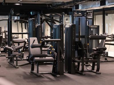 Gimnasio moderno con equipos de entrenamiento de fuerza y asientos acolchados en un hotel