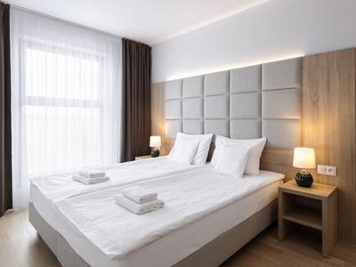 Camera d'hotel moderna con letto matrimoniale, colori neutri e luce naturale
