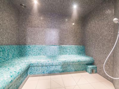Sala vapore moderna con piastrelle a mosaico turchese e doccia.