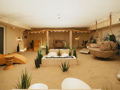 Amplia sala acogedora con asientos modernos, suculentas y tonos beige cálidos.