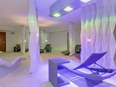 Área de bienestar moderna con asientos lounge y luz suave.