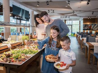 Famiglia che sceglie cibo fresco a un buffet in un ristorante di un hotel.