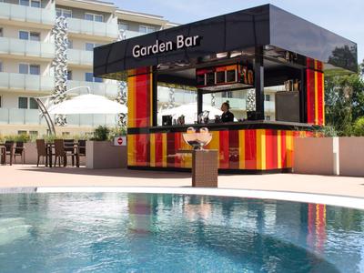 Padiglione moderno del bar da giardino con design colorato vicino a una piscina d'hotel.