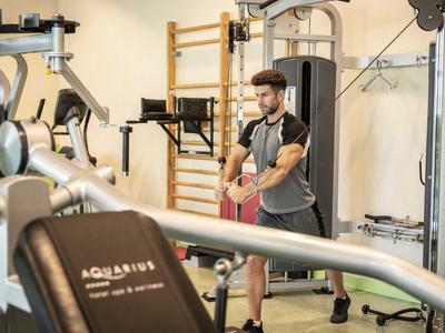 Palestra moderna con attrezzi e uomo che si prepara ad allenarsi.
