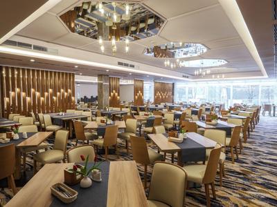 Área de comedor elegante del hotel con muebles modernos e iluminación cálida.