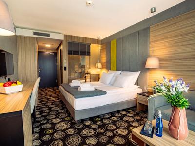 Modern eingerichtetes Hotelzimmer mit Doppelbett, Teppichboden und Schreibtisch.