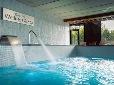 Modernes Hallenbad mit Wasserfontänen in einem Wellness- und Spa-Bereich.