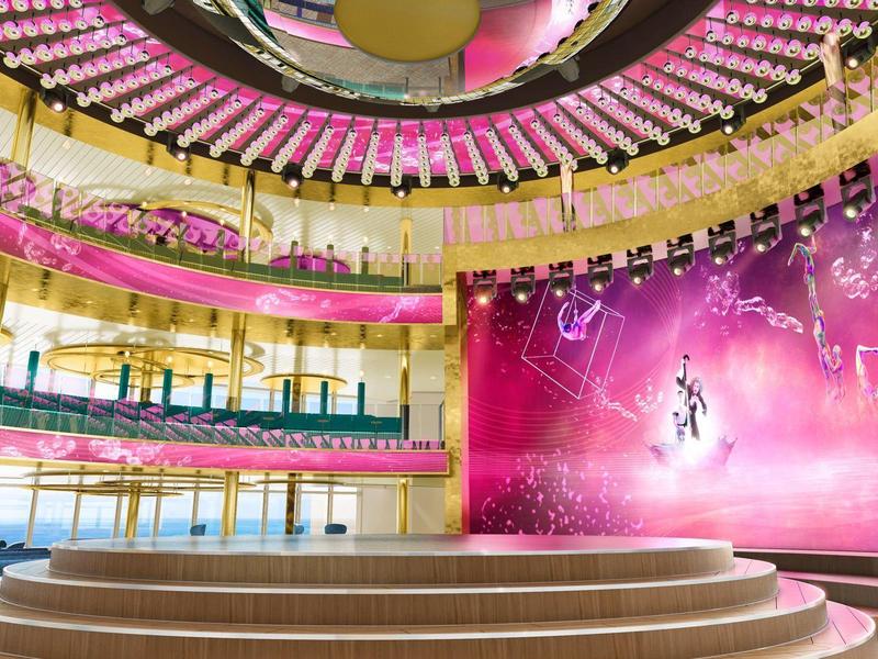 Lichte hotel lobby met ronde podium, roze bloemendecoraties en grote kleurrijke wanddecoratie.