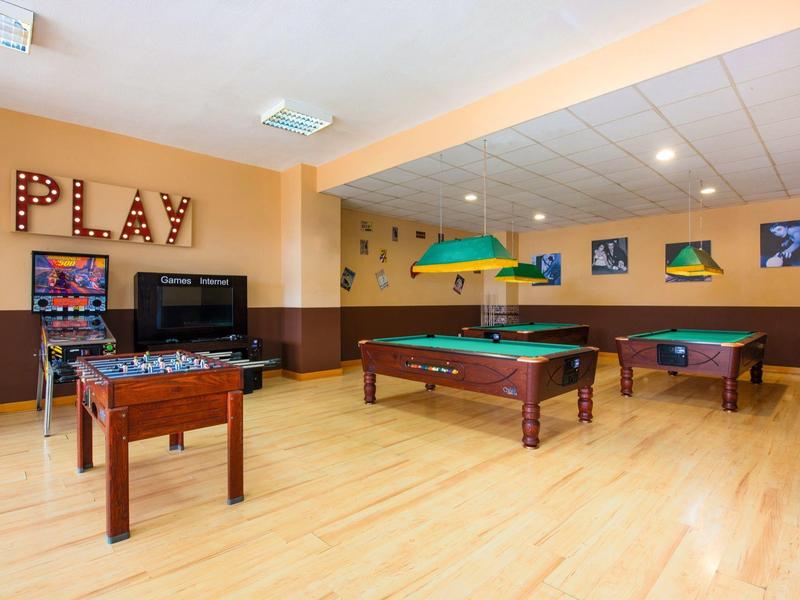 Recreatieruimte met tafelvoetbal, pooltafel en dartbord in warm verlichte ruimte