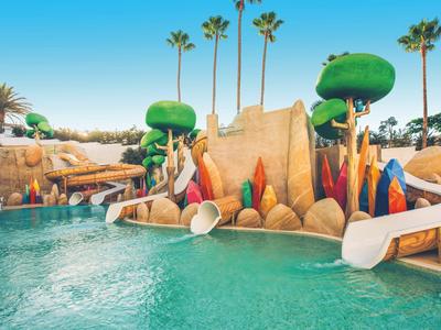 Colorful water park with slides and a pool under a clear sky.
