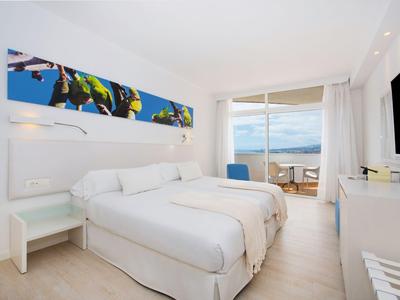 Moderne hotelkamer met twee eenpersoonsbedden, balkon en uitzicht op zee.